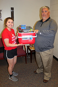Emma Dillon receives gift basket from Wellington Middle School vice principal Brian Aufdengarten.