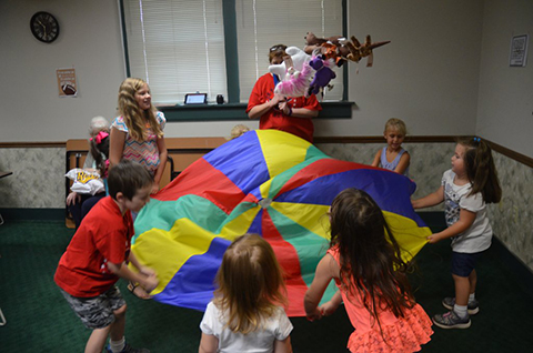 Stuffed teddy bears and other toys get thrown in the air to the delight of children.