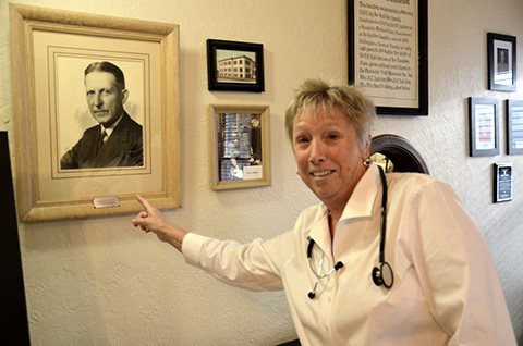 Collette Kocour of Wellington points to Dr. A.E. Hatcher's portrait.