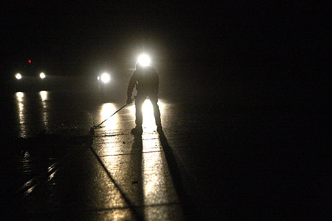 An unidentified worker cleans up after two-car fatality accident Saturday evening.